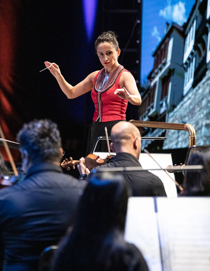 Bisera Chadlovska conducting an orchestra on stage